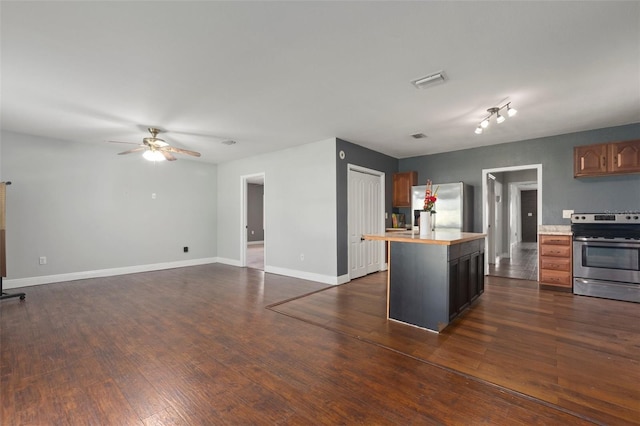 kitchen featuring dark hardwood / wood-style flooring, stainless steel appliances, a kitchen island, and ceiling fan