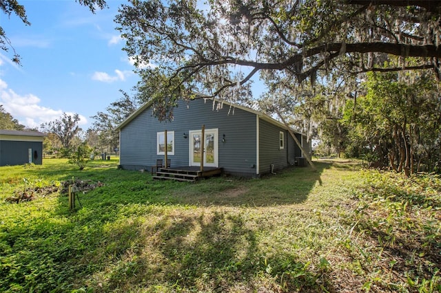 back of house featuring a lawn and a deck