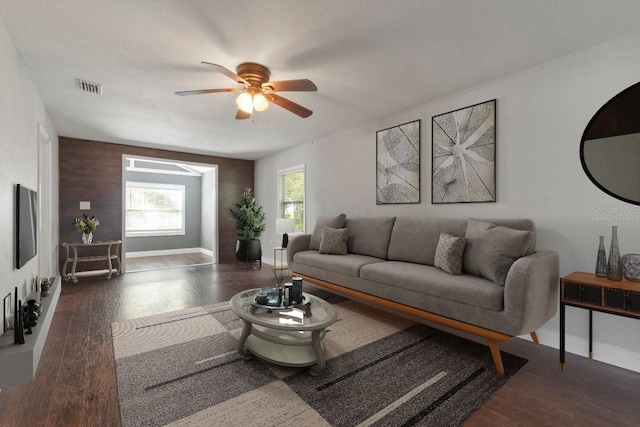 living room with dark hardwood / wood-style flooring and ceiling fan