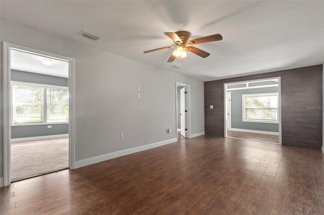 empty room with ceiling fan and dark wood-type flooring