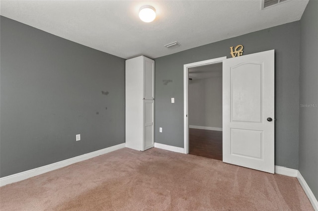 unfurnished bedroom featuring light colored carpet and a closet