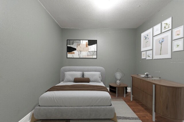 bedroom featuring a textured ceiling and dark wood-type flooring