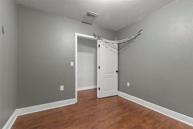 unfurnished bedroom with wood-type flooring and a textured ceiling