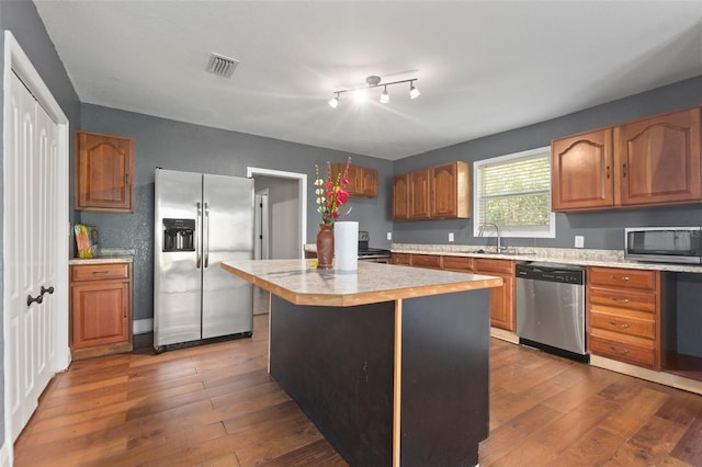 kitchen featuring stainless steel appliances, a kitchen island, dark hardwood / wood-style floors, and sink