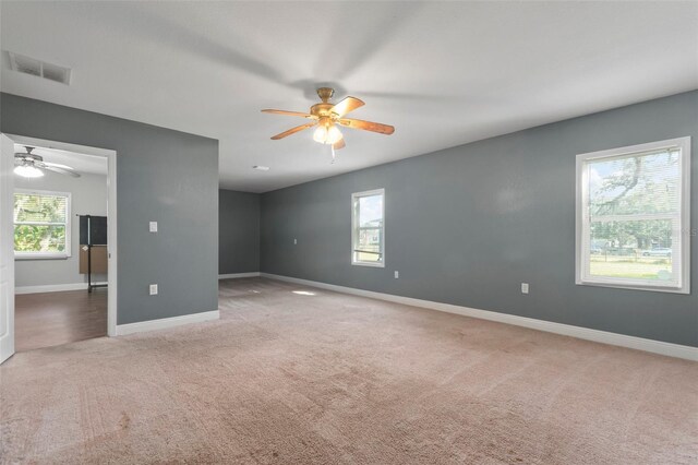 unfurnished room featuring ceiling fan, a healthy amount of sunlight, and carpet floors