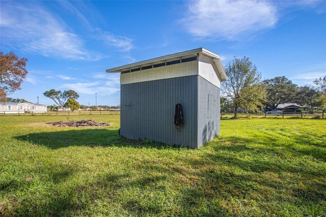 view of outdoor structure featuring a lawn and a rural view