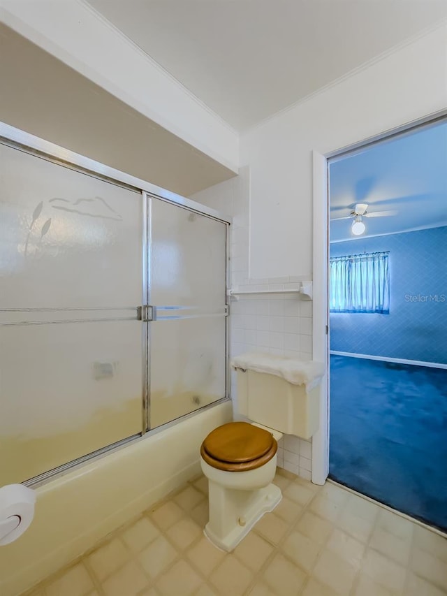 bathroom with ceiling fan, toilet, ornamental molding, and bath / shower combo with glass door