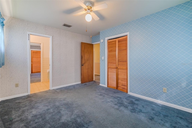 unfurnished bedroom with ceiling fan, a closet, and carpet floors