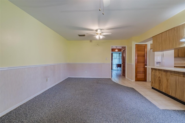 kitchen with ceiling fan, white fridge with ice dispenser, and light colored carpet