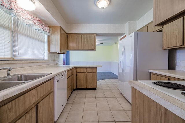 kitchen featuring decorative backsplash, white appliances, sink, and light tile patterned floors