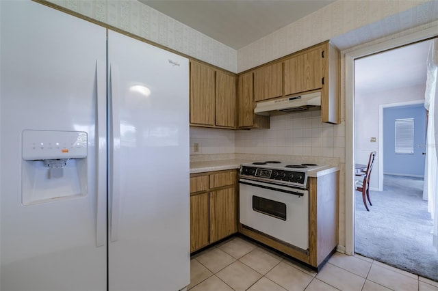 kitchen featuring white appliances, light carpet, and tasteful backsplash