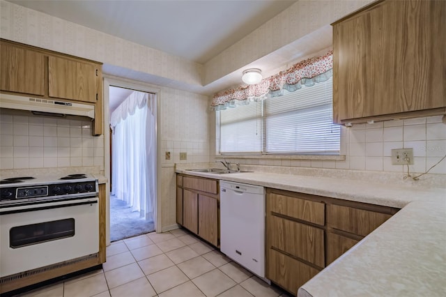 kitchen featuring tasteful backsplash, sink, light tile patterned floors, and white appliances