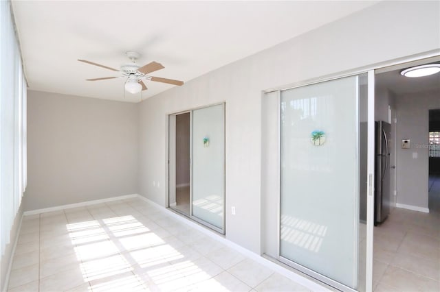 spare room with ceiling fan and light tile patterned floors