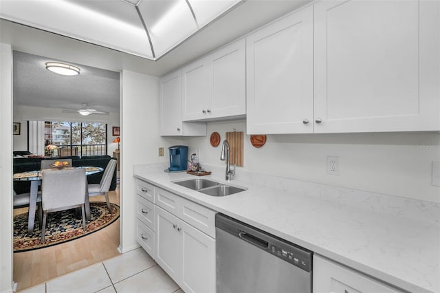 kitchen with stainless steel dishwasher, a sink, white cabinetry, and a ceiling fan