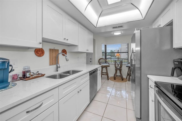 kitchen with light tile patterned floors, visible vents, appliances with stainless steel finishes, white cabinets, and a sink