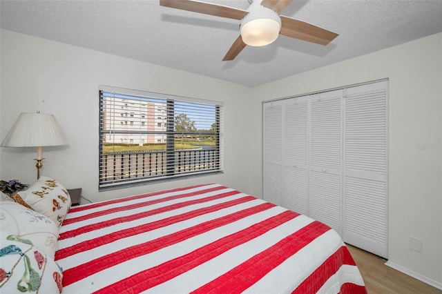 bedroom featuring a closet, ceiling fan, a textured ceiling, and wood finished floors