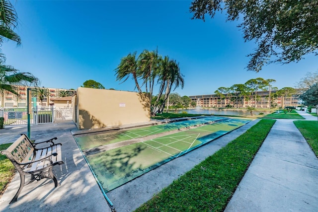 view of home's community with a gate, fence, and shuffleboard