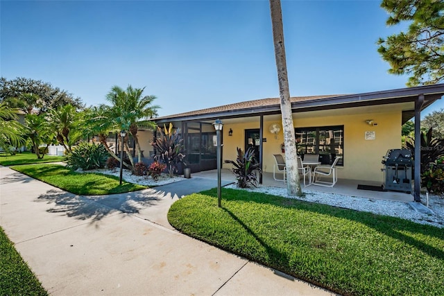 view of front of property featuring a front lawn and stucco siding