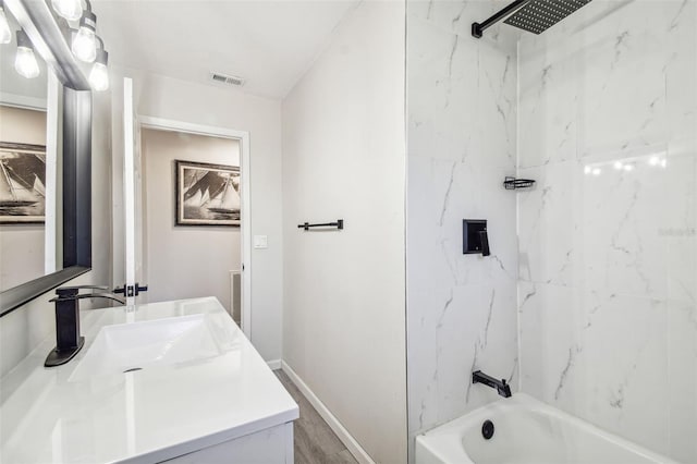 bathroom featuring vanity and tiled shower / bath