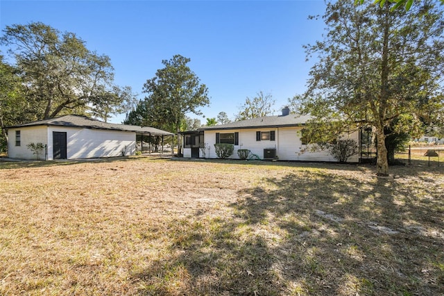 view of front of property with a front yard and central AC unit