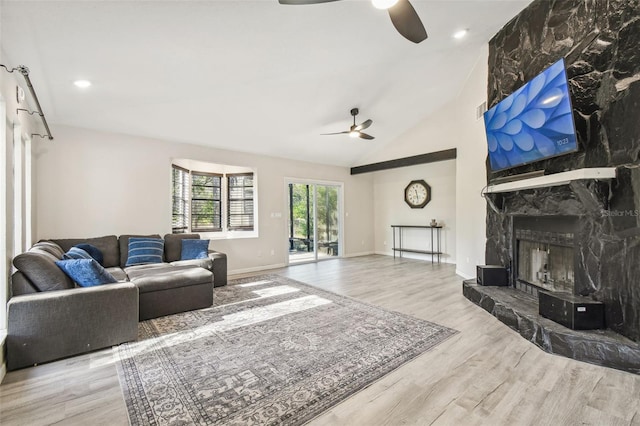 living room with a fireplace, light hardwood / wood-style floors, high vaulted ceiling, and ceiling fan