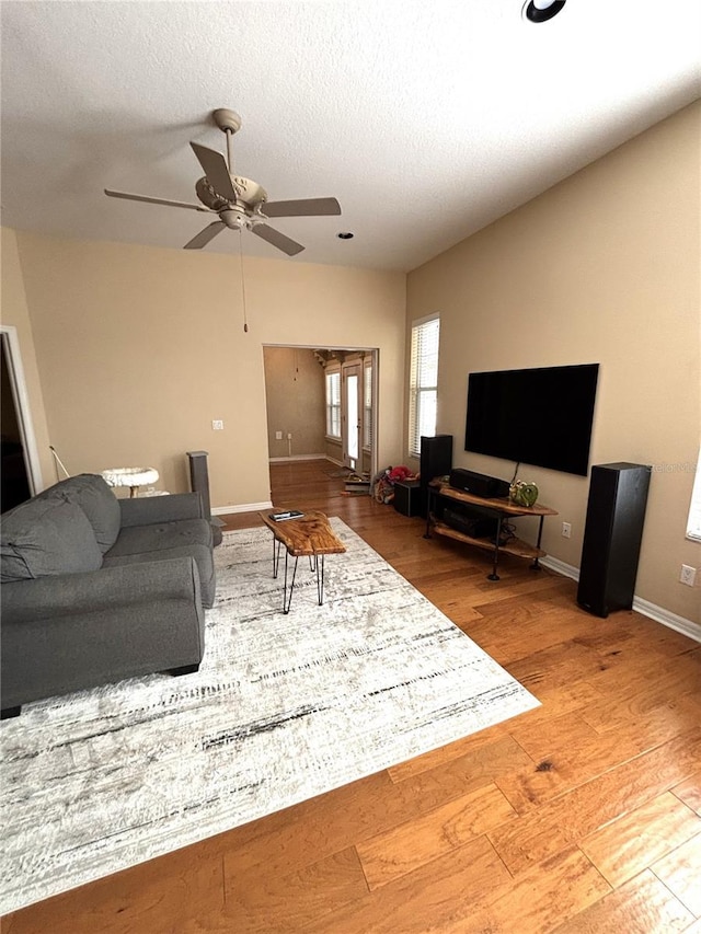 living room with hardwood / wood-style floors, a textured ceiling, and ceiling fan