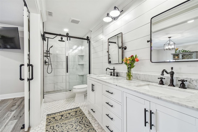 bathroom with hardwood / wood-style floors, vanity, an enclosed shower, and crown molding