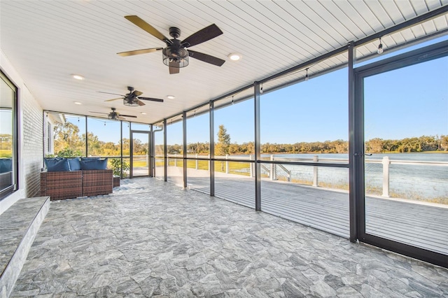 unfurnished sunroom featuring ceiling fan, plenty of natural light, and wooden ceiling