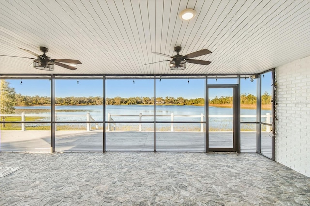 unfurnished sunroom with ceiling fan and a water view