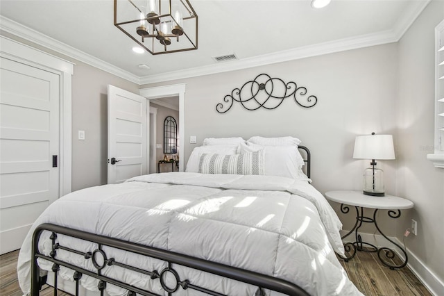 bedroom featuring a chandelier, hardwood / wood-style floors, and crown molding