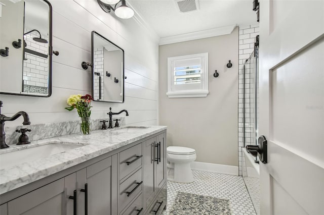 full bathroom with tile patterned floors, ornamental molding, vanity,  shower combination, and toilet