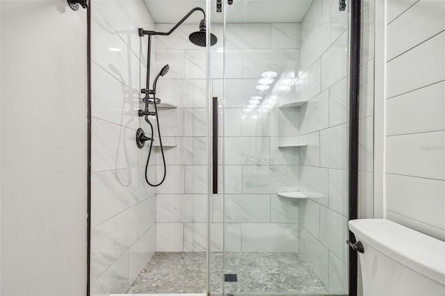 bathroom with toilet and a shower with shower door