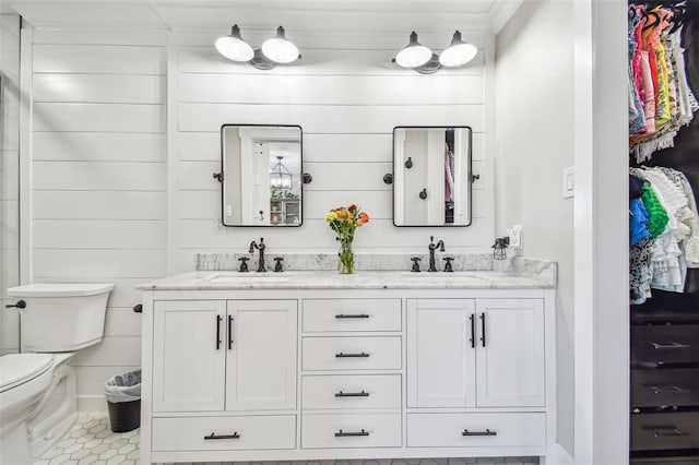 bathroom with tile patterned flooring, vanity, toilet, and wooden walls