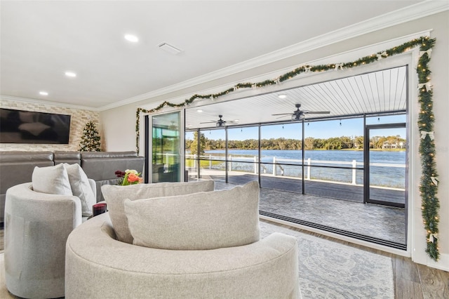 living room with hardwood / wood-style floors, a water view, and ornamental molding