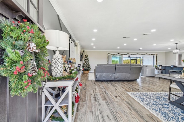 living room with light hardwood / wood-style flooring and crown molding