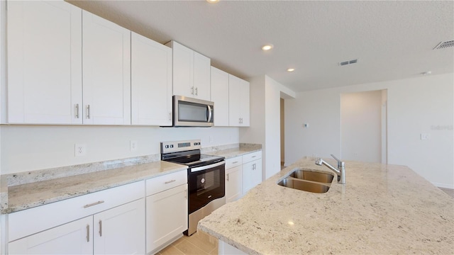 kitchen with light stone counters, white cabinetry, sink, and appliances with stainless steel finishes