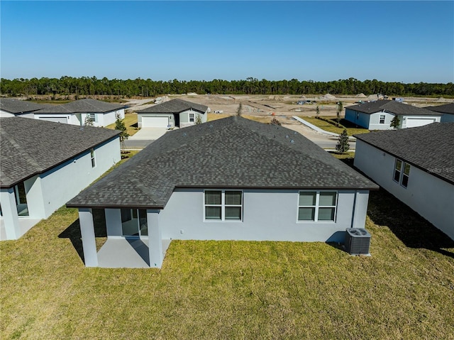 back of property with a lawn, central AC unit, and a patio