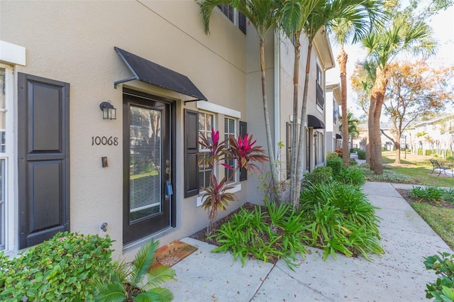 view of exterior entry featuring stucco siding