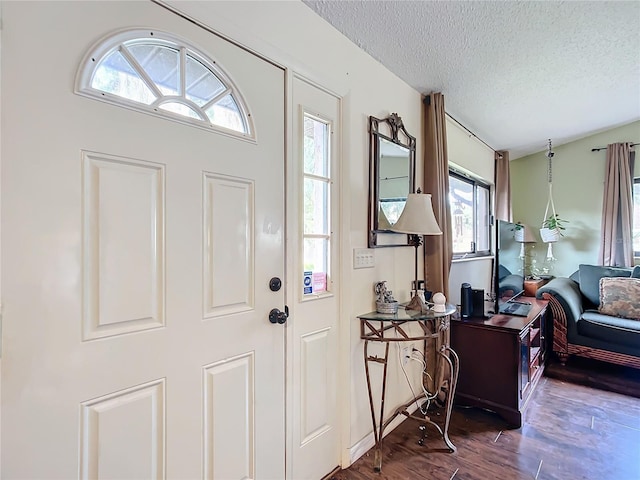 foyer entrance featuring dark hardwood / wood-style floors and a textured ceiling