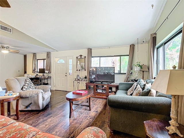 living room with ceiling fan, dark wood-type flooring, and vaulted ceiling