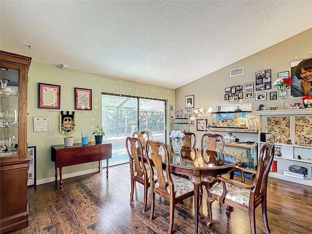 dining area featuring dark hardwood / wood-style flooring, lofted ceiling, and a textured ceiling