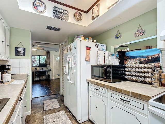 kitchen featuring white cabinets, ceiling fan, white appliances, and tasteful backsplash