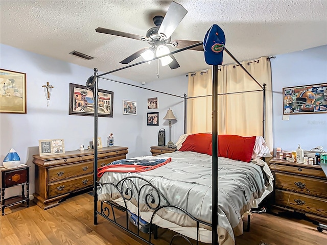 bedroom featuring ceiling fan, a textured ceiling, and hardwood / wood-style flooring