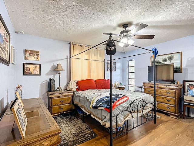 bedroom featuring hardwood / wood-style floors, a textured ceiling, and ceiling fan