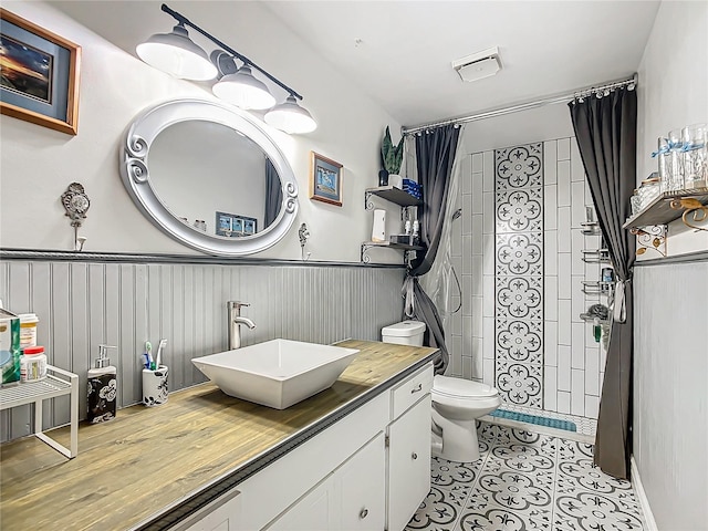 bathroom with tile patterned floors, vanity, curtained shower, and toilet