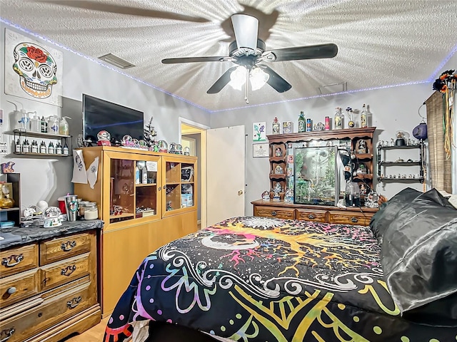 bedroom featuring ceiling fan and a textured ceiling