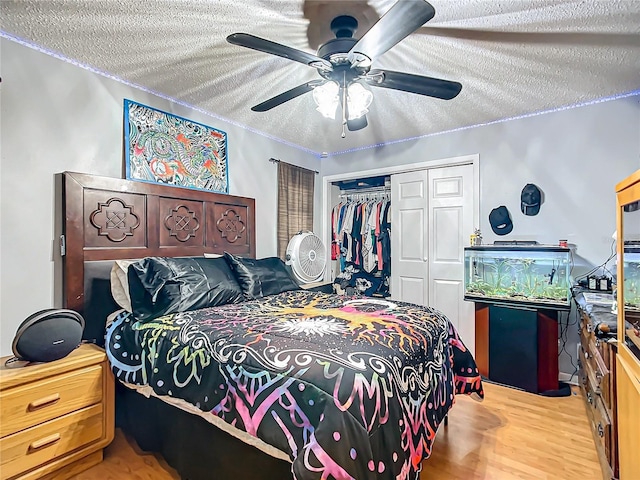 bedroom with ceiling fan, a closet, a textured ceiling, and light wood-type flooring