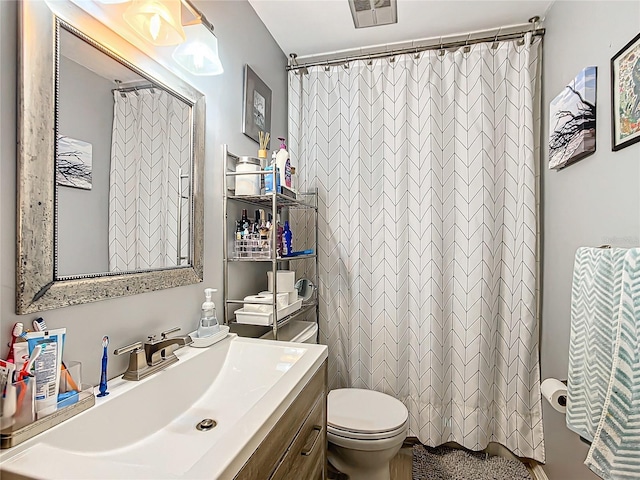 bathroom featuring vanity, toilet, and walk in shower