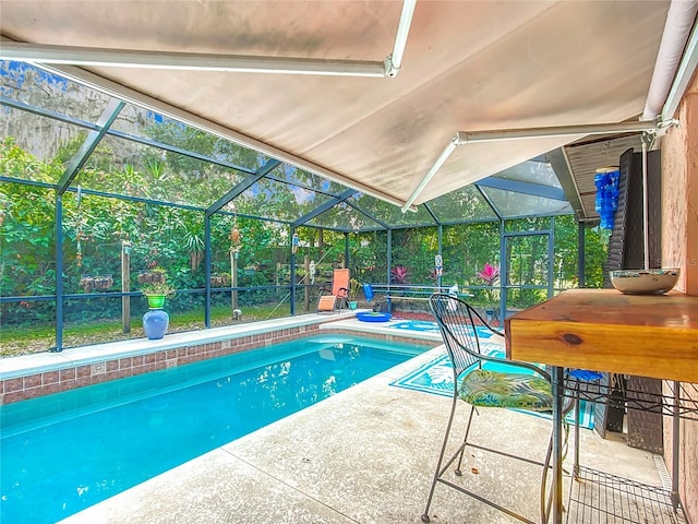 view of swimming pool with a patio area and a lanai