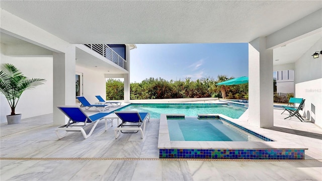 view of swimming pool featuring a patio area and a pool with connected hot tub